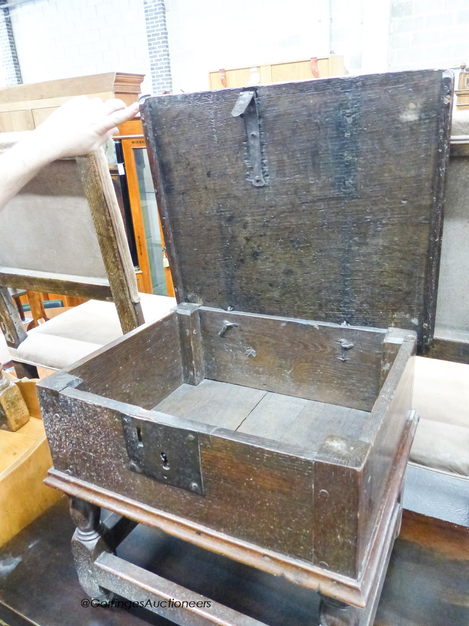 A 17th century oak box stool with hinged rectangular seat, width 46cm, depth 38cm, height 42cm